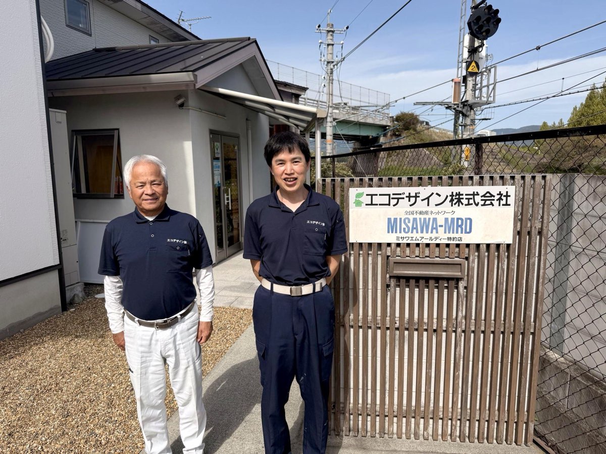 エコデザイン株式会社の看板の前に立つ、代表の中田様とお父様